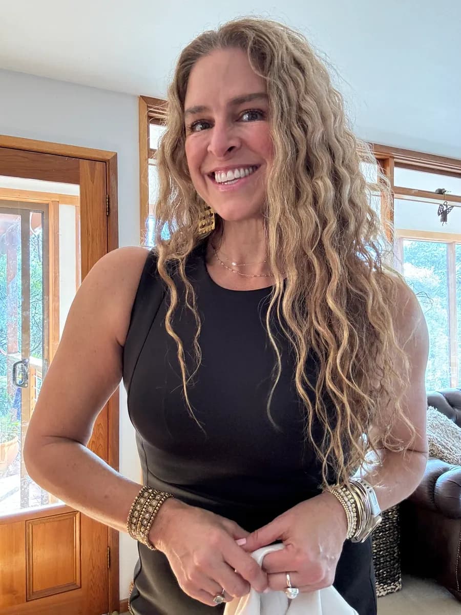 Dr Rebecca Chabot in a black dress, smiling in a sunlit room